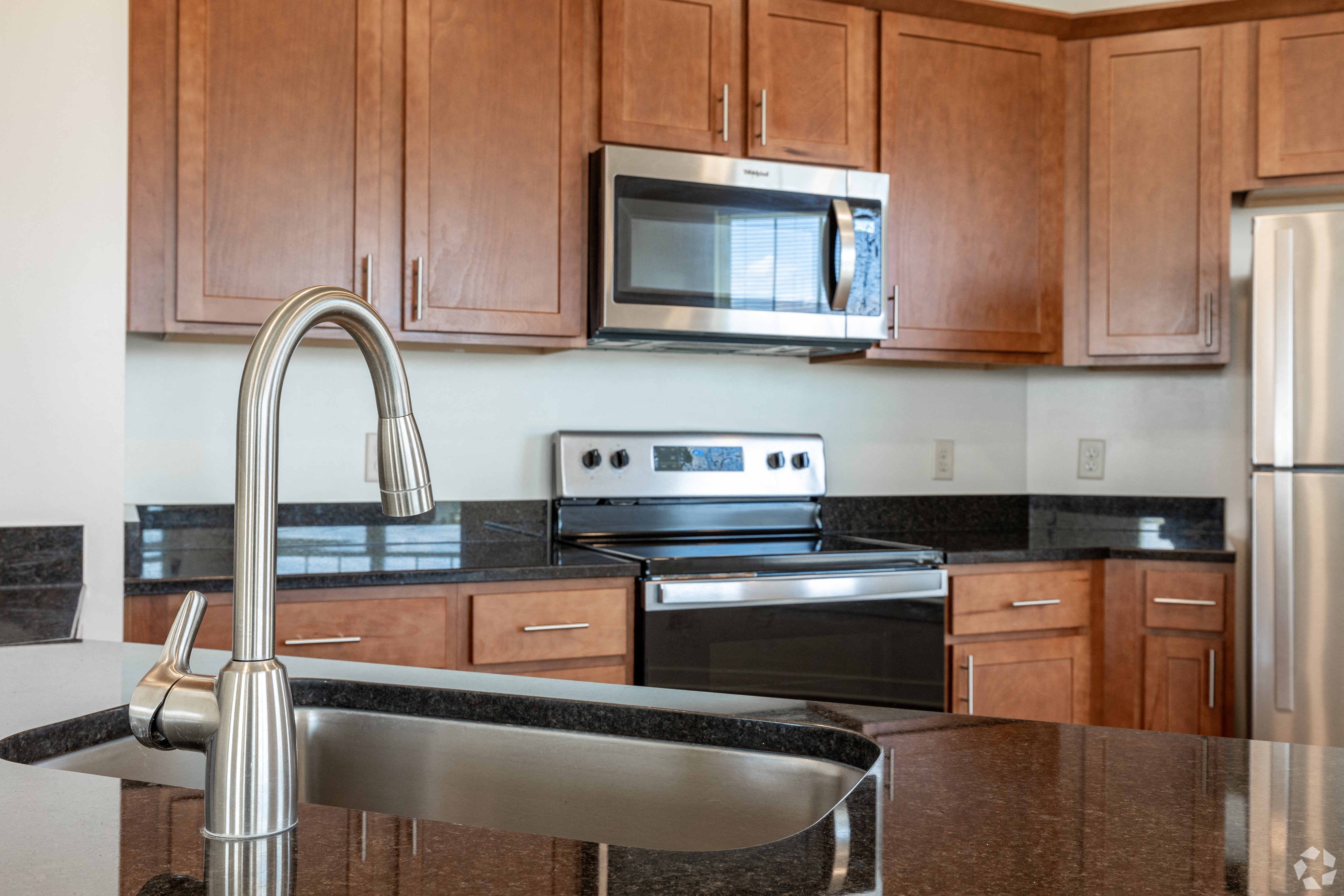 a kitchen with granite counter tops and wooden cabinets